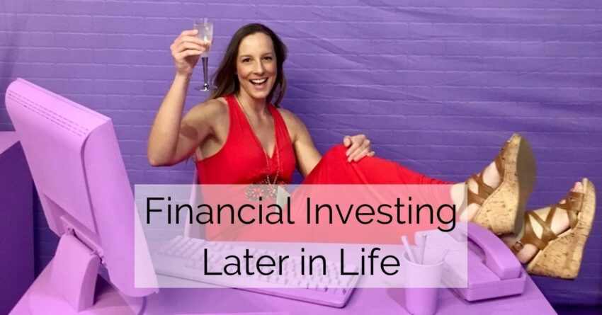 "financial investing later in life" text on photo of woman raising a glass of champagne at a fake purple office desk